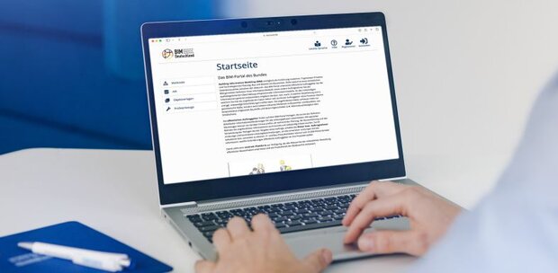 Eine Person arbeitet an einem Laptop, auf welchem die Startseite der BIM Bundesfernstraßen-Webseite zu sehen ist. 